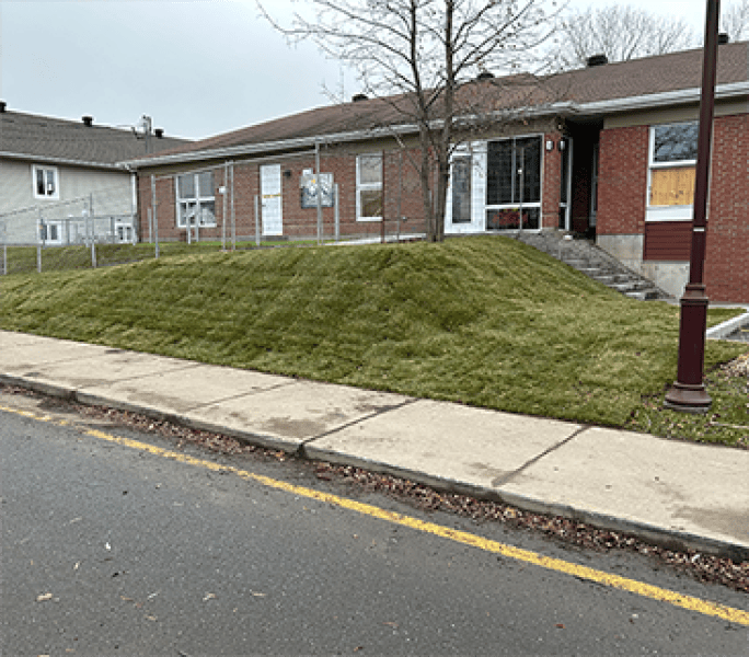 Pose de tourbe sur talus devant immeuble – Aménagement Marosa à Montmagny